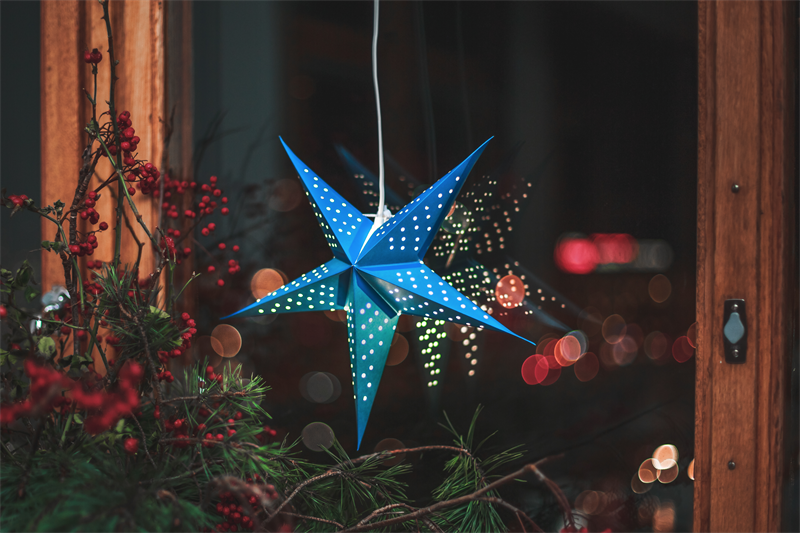 Bris blå julstjärna hänger i ett fönster