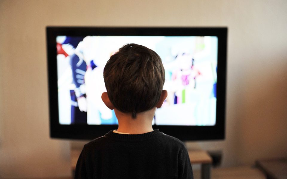 Ett barn sitter framför tv:n.