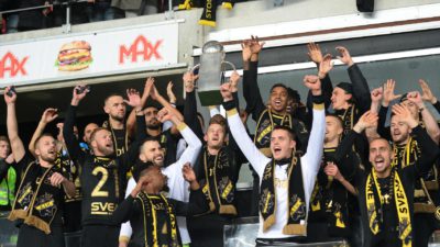 Bild på AIK:s lag som tillsammans höjer bucklan.